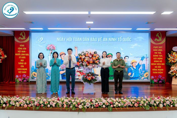 Đồng chí Cấn Thị Việt Hà - Bí thư Đảng uỷ, Chủ tịch HĐND phường Dương Nội cùng lãnh đạo Công an phường Dương Nội tặng hoa chúc mừng Bệnh viện. (Ảnh: Bệnh viện Nhi Hà Nội)