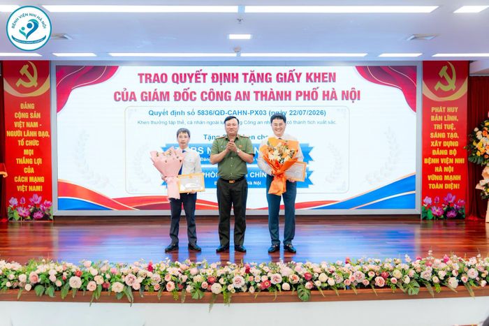 Đại tá Nguyễn Tiến Đạt – Phó Giám đốc Công an Thành phố Hà Nội trao Giấy khen cho TS.BS. Ngô Quang Hùng - Giám đốc Bệnh viện Nhi Hà Nội và tập thể Phòng Hành chính quản trị - Bệnh viện Nhi Hà Nội. (Ảnh: Bệnh viện Nhi Hà Nội)
