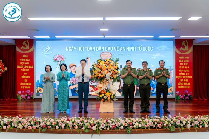 Đại tá Nguyễn Tiến Đạt – Phó Giám đốc Công an Thành phố Hà Nội cùng các đồng chí lãnh đạo Phòng An ninh chính trị nội bộ, Phòng Tham mưu Công an Thành phố Hà Nội tặng hoa chúc mừng Bệnh viện Nhi Hà Nội. (Ảnh: Bệnh viện Nhi Hà Nội)