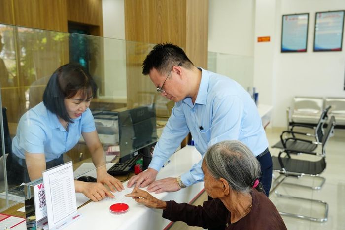 Ông Phan Thanh Giang - Giám đốc QTDND Tân Phong hướng dẫn khách hàng người cao tuổi