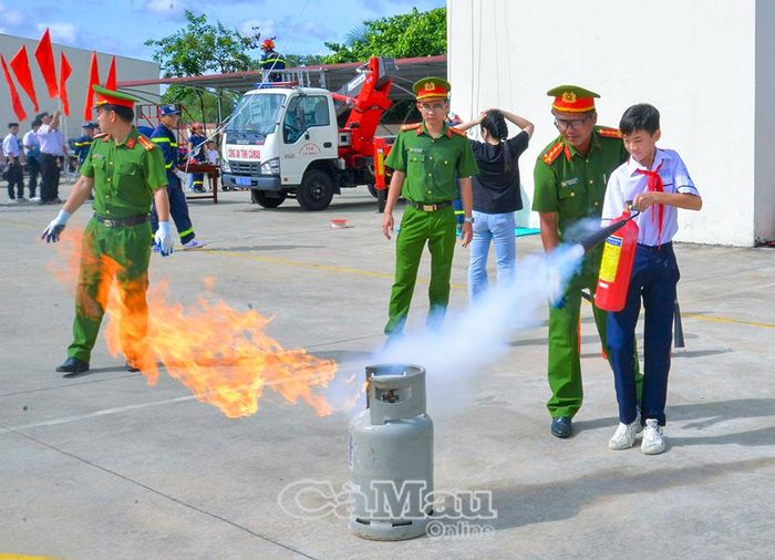 Học sinh thực hành sử dụng bình chữa cháy dưới sự hướng dẫn của cán bộ, chiến sĩ Công an.