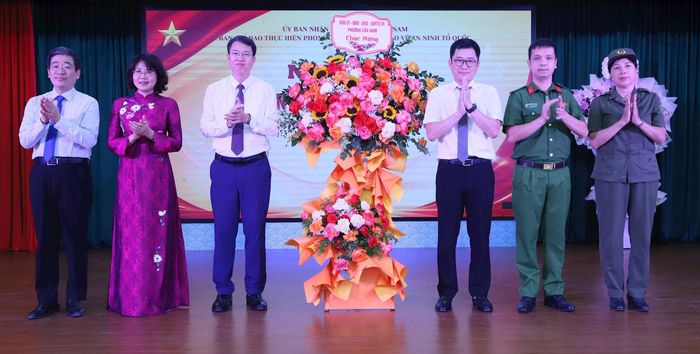 Đảng ủy - HĐND - UBND - Ủy ban MTTQ Việt Nam phường tặng hoa chúc mừng ngày hội. Ảnh: PV