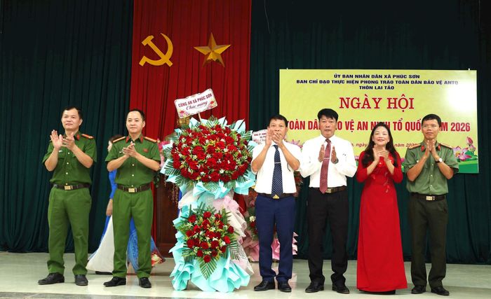 Lãnh đạo Công an xã Phúc Sơn chúc mừng Ngày hội toàn dân bảo vệ an ninh Tổ quốc tại thôn Lai Tảo. Ảnh: Kim Nhuệ