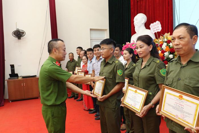 Thượng tá Lê Minh Thanh, Trưởng công an xã Hồng Vân, tặng giấy khen cho lực lượng an ninh cơ sở. Ảnh: Vũ Cường.