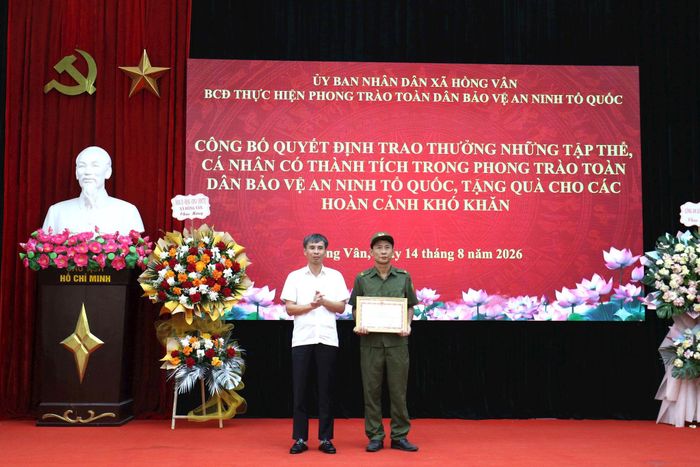 Bí thư Đảng ủy xã Hồng Vân Phạm Tiến Dũng trao Bằng khen của Bộ trưởng Bộ Công an cho Tổ tham gia bảo vệ an ninh trật tự ở cơ sở thôn Nỏ Bạn. Ảnh: Vũ Cường.
