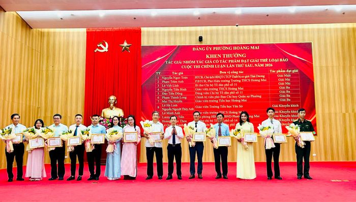 Chủ tịch Ủy ban MTTQ Việt Nam phường Hoàng Mai Triệu Hải Vân trao giải cho các tác giả, nhóm tác giả đạt giải ở thể loại báo. Ảnh: Trần Oanh