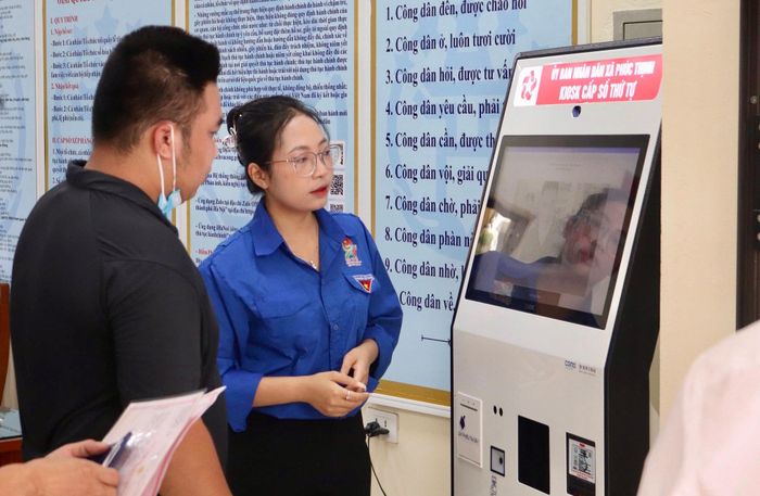 Đoàn viên thanh niên xã Phúc Thịnh hỗ trợ người dân thực hiện thủ tục hành chính. Ảnh: Thanh Hà