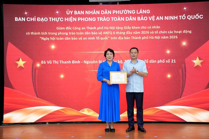 Bà Vũ Thị Thanh Bình nhận giấy khen của Giám đốc Công an TP Hà Nội. Ảnh: Phạm Mạnh