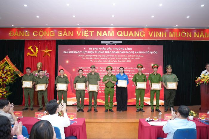 Trung tá Trần Văn Hiếu, Phó trưởng Công an phường Láng trao giấy khen cho các tập thể có thành tích trong Thực hiện khu dân cư, phường, cơ quan, doanh nghiệp đạt tiêu chuẩn "An toàn về an ninh, trật tự" giai đoạn 2021 - 2026. Ảnh: Phạm Mạnh