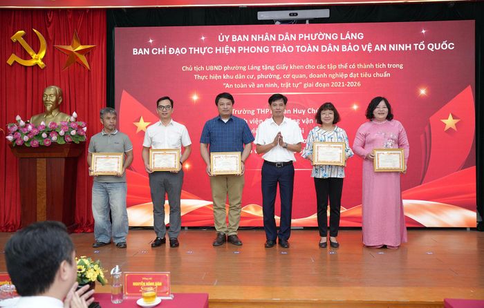 Đồng chí Vũ Xuân Tiến, Ủy viên Ban thường vụ Đảng ủy, Phó Chủ tịch UBND phường Láng trao giấy khen cho các tập thể có thành tích trong Thực hiện khu dân cư, phường, cơ quan, doanh nghiệp đạt tiêu chuẩn "An toàn về an ninh, trật tự" giai đoạn 2021 - 2026. Ảnh: Phạm Mạnh