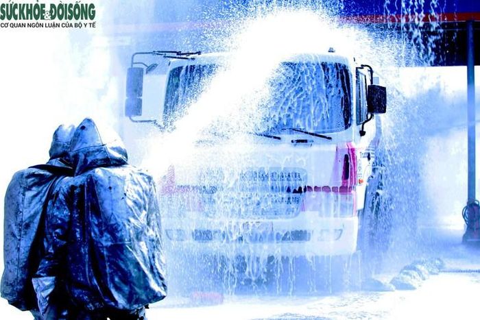 Lực lượng chữa cháy trong trang phục bảo hộ tiếp cận, phun nước làm mát xe bồn trong tình huống diễn tập. Ảnh: V. Đồng.