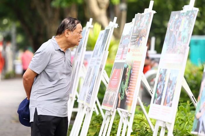 Không chỉ du khách quốc tế, nhiều người dân Thủ đô cũng đứng lâu trước những tấm ảnh ghi lại chiến công của Công an Hà Nội