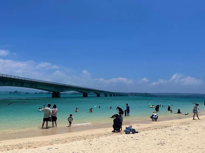 Du khách thư giãn ở bãi biển cạnh cây cầu Kouri nổi tiếng