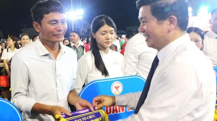 Phó Bí thư Thường trực Tỉnh ủy, Trưởng đoàn đại biểu Quốc hội tỉnh Quảng Trị Trần Vũ Khiêm trao cờ lưu niệm cho các đoàn vận động viên. (Ảnh: HƯƠNG GIANG)