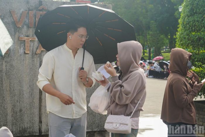 Các bạn trẻ tranh thủ ăn sáng trong khi chờ đợi.