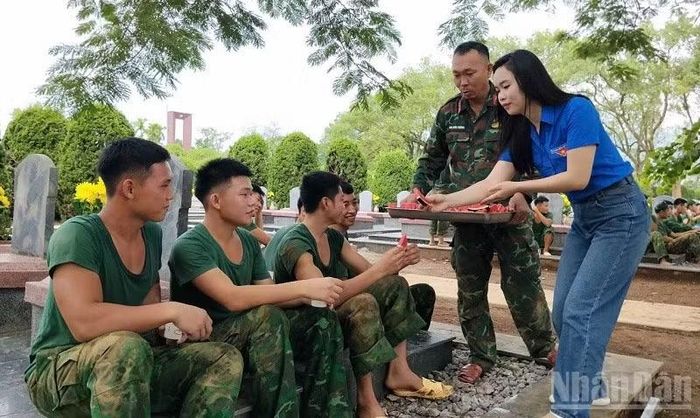 Đoàn viên, thanh niên Trường trung học phổ thông Thanh Nưa động viên cán bộ, chiến sĩ Bộ Chỉ huy Quân sự tỉnh Điện Biên đang thực hiện "Chiến dịch 500 ngày đêm" tại Nghĩa trang liệt sĩ Độc Lập. (Ảnh: LÊ LAN)