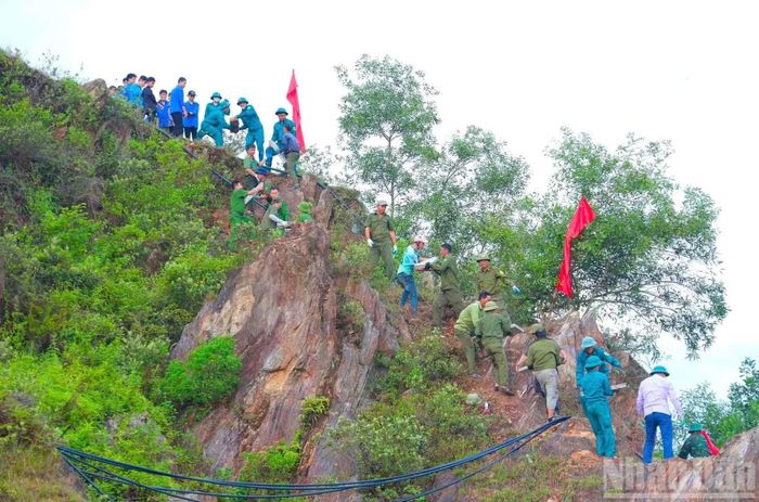 Hàng nghìn người chung sức tái tạo dòng chữ “Bác Hồ sống mãi” trên núi Nhón. (Ảnh: H.H)