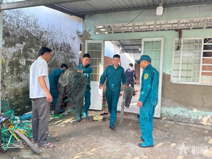Lực lượng dân quân tự vệ của Ban CHQS xã Hưng Mỹ giúp người dân dọn dẹp nhà cửa.