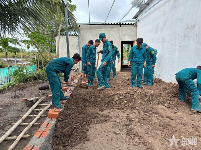 Cán bộ, chiến sĩ Ban CHQS xã Hưng Mỹ (Cà Mau) giúp bà con vận chuyển đất đắp nền nhà.