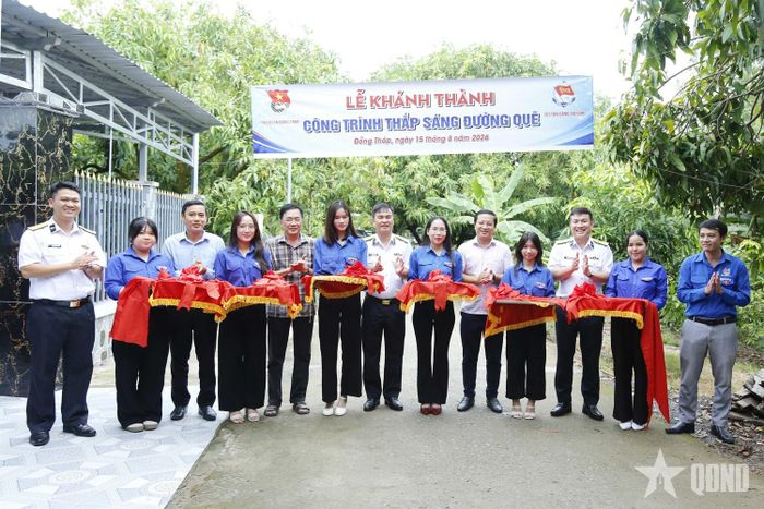 Các đại biểu cắt băng khánh thành công trình thắp sáng đường quê. 