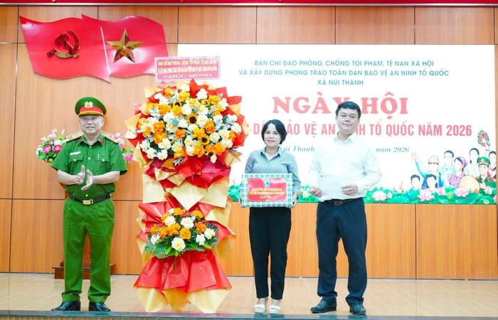 Đại tá Nguyễn Văn Tăng - Phó Giám đốc Công an TP Đà Nẵng tặng hoa chúc mừng Ngày hội toàn dân bảo vệ an ninh Tổ quốc xã Núi Thành.
