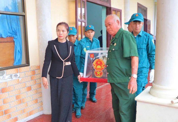  Bà Nguyễn Thị Thương (bên trái), Chủ tịch UBND xã Đăk Pék đưa các hài cốt liệt sĩ đến nơi an táng. Ảnh: UBND xã cung cấp 