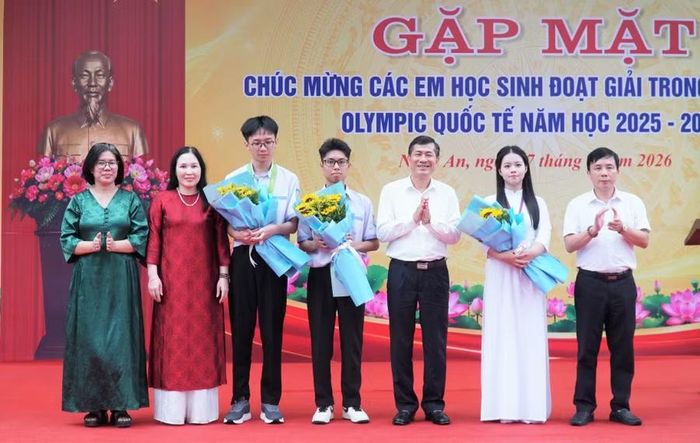 Ông Thái Văn Thành - Phó Chủ tịch UBND tỉnh Nghệ An chúc mừng các em học sinh đạt giải tại các cuộc thi Olympic quốc tế và khu vực cùng tập thể Trường THPT chuyên Phan Bội Châu. Ảnh: Hồ Lài