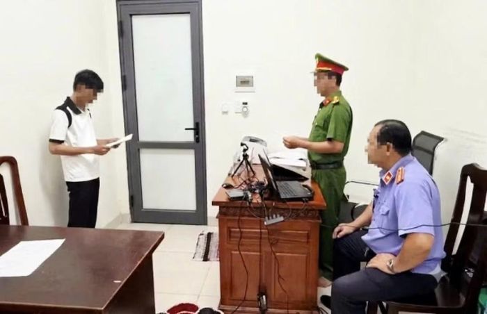 Cơ quan điều tra thi hành quyết định khởi tố bị can đối với N.H.D. Ảnh: CACM.