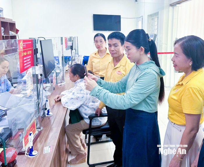 Cán bộ Mặt trận xã Anh Sơn hướng dẫn người dân đóng góp ý kiến online về thực hiện thủ tục hành chính và chuyển đổi số tại Trung tâm Phục vụ hành chính công xã. Ảnh: Mai Hoa