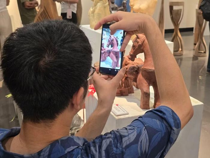 Du khách chụp lại tác phẩm điêu khắc đoạt giải B. (Ảnh: Minh Anh/Vietnam+)