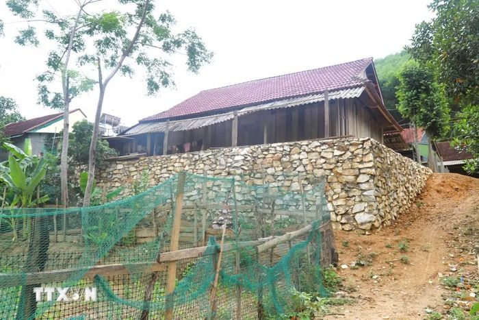 Tình trạng sạt lở ven suối diễn biến phức tạp nên nhiều hộ dân phải gia cố bờ đất quanh nhà bằng những bờ kè cao để hạn chế nguy cơ sạt lở trong mùa mưa. (Ảnh: Xuân Tiến/TTXVN)