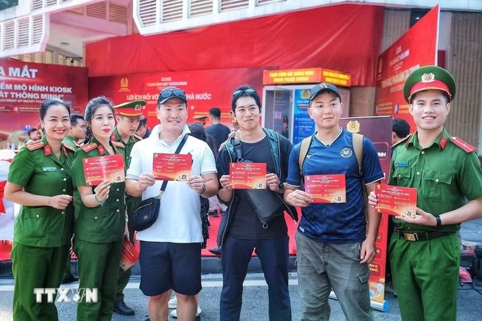 Cán bộ Công an Việt Nam và cảnh sát Nhật Bản chụp ảnh lưu niệm tại khu vực triển khai thí điểm mô hình Kiosk “Trạm Cảnh sát thông minh”. (Ảnh: Phạm Tuấn Anh/TTXVN)