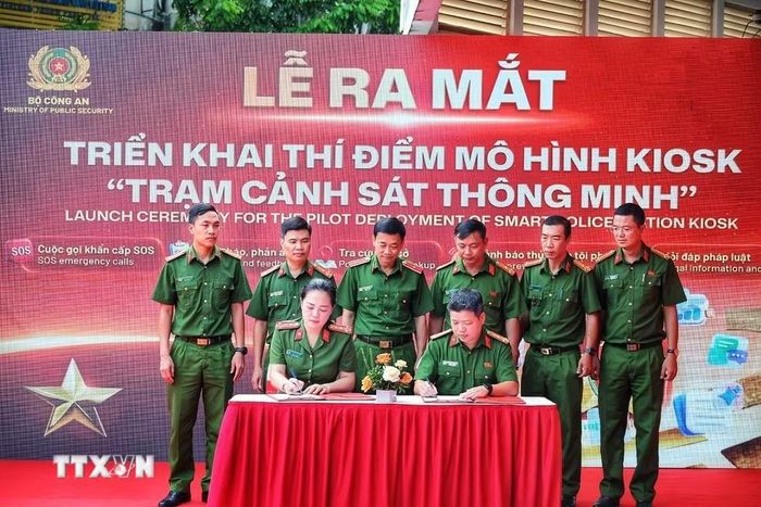 Đại diện các đơn vị ký kết phối hợp triển khai thí điểm mô hình Kiosk “Trạm Cảnh sát thông minh”. (Ảnh: Phạm Tuấn Anh/TTXVN)