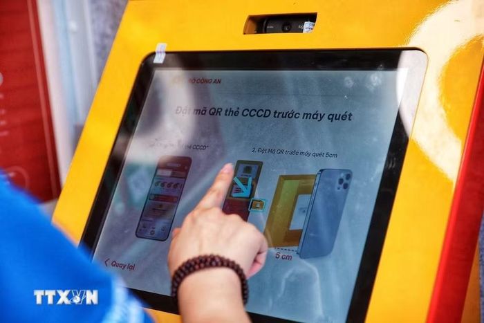Kiosk hướng dẫn người dân xác thực bằng mã QR trên căn cước hoặc thông qua ứng dụng VNeID để thực hiện các chức năng trên hệ thống. (Ảnh: Phạm Tuấn Anh/TTXVN)