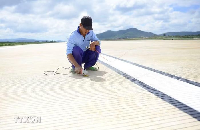 Công nhân hoàn thành chỉnh trang từng phần nhỏ nhất để đảm bảo mặt đường cất-hạ cánh mới có chất lượng tốt nhất. (Ảnh: Nguyễn Dũng/TTXVN)