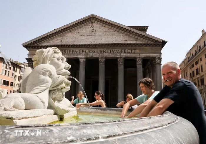 Khách du lịch làm mát tại đài phun nước ở Rome, Italy, ngày 19/7/2026. Italy đang trải qua đợt nắng nóng nghiêm trọng thứ tư trong mùa Hè, với nhiệt độ tại một số khu vực vượt 40 độ C và số thành phố được đặt ở mức cảnh báo nắng nóng cao nhất đạt mức kỷ lục. (Ảnh: THX/TTXVN phát)