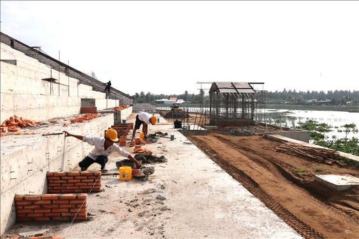Khán đài đua ghe Ngo của công trình kè chống sạt lở bờ sông Láng Thé kết hợp khán đài đua ghe Ngo (xã Bình Phú) đang được đẩy nhanh tiến độ để hoàn thành, đưa vào sử dụng trong tháng 9/2026.