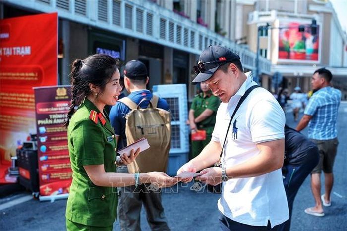 Cán bộ Công an giới thiệu, hướng dẫn người dân tìm hiểu các tiện ích của mô hình Kiosk “Trạm Cảnh sát thông minh”. Ảnh: Phạm Tuấn Anh/TTXVN