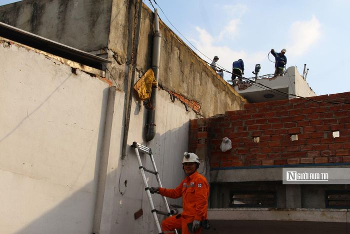 Giữa cái nắng gắt, các công nhân ngành điện lực và viễn thông đang leo cao trên trụ điện để ngắt kết nối, di dời hệ thống đường dây, cáp quang vào sát mép ranh giới mới, bảo đảm an toàn hành lang thi công và không làm gián đoạn sinh hoạt của người dân.