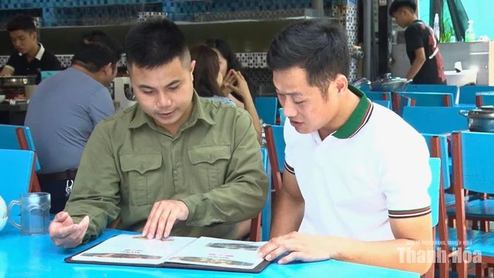 Anh Cao Hùng Sơn (áo xanh) giới thiệu với khách hàng các sản phẩm hải sản tại nhà hàng.