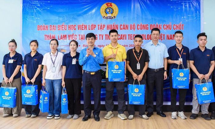  Các đồng chí Trần Huy Phương và Lê Văn Nghĩa tặng quà đoàn viên Công đoàn Công ty Cayi Technology Việt Nam. 