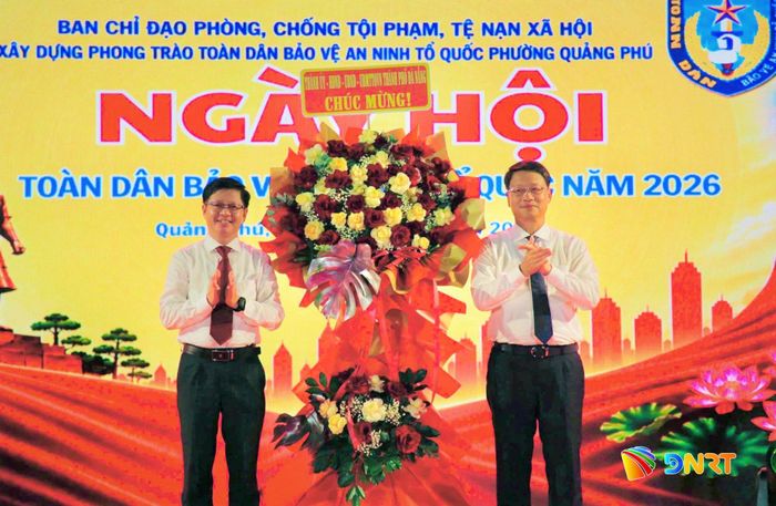 Phó Bí thư Thành ủy Ngô Xuân Thắng (bên phải) tặng lẵng hoa của Thành ủy, HĐND, UBND, Ủy ban MTTQ Việt Nam thành phố chúc mừng ngày hội. Ảnh: ALĂNG NGƯỚC
