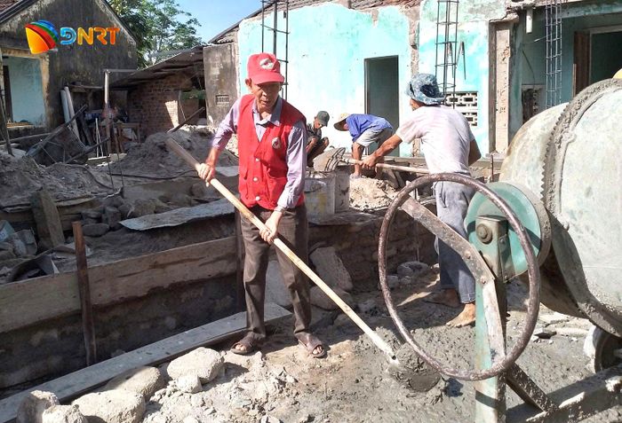 Ông Nguyễn Hữu Quang tham gia xây dựng nhà Chữ thập đỏ cho hộ nghèo tại địa phương. Ảnh: HỮU TRUNG