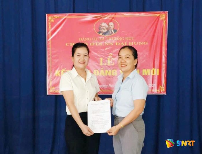 Chi bộ Hợp tác xã Nông nghiệp Đại Hưng trao quyết định kết nạp đảng viên cho nhân viên Trần Thị Hoài Linh. Ảnh: KHẢI KHIÊM