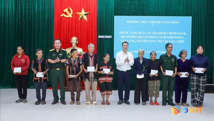 Lãnh đạo thành phố tặng quà cho hộ nghèo tại xã La Dêê. Ảnh: NGỌC PHÚ