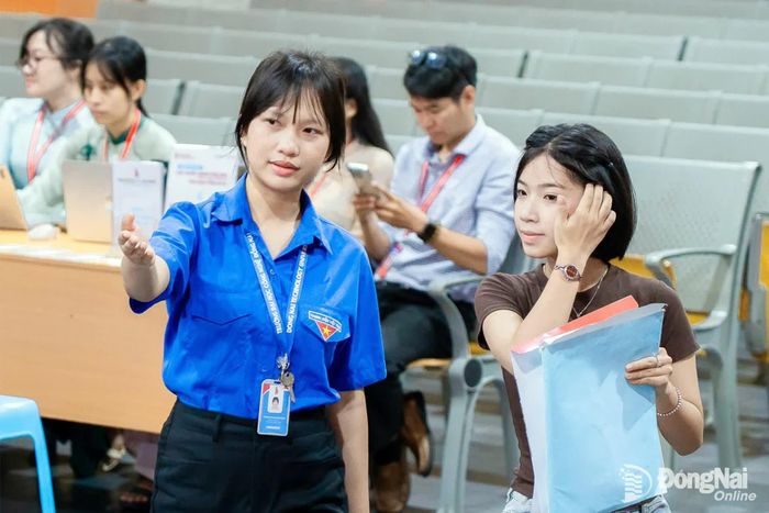Sinh viên tình nguyện hướng dẫn tân sinh viên thực hiện thủ tục nhập học. Ảnh: Như Thuật