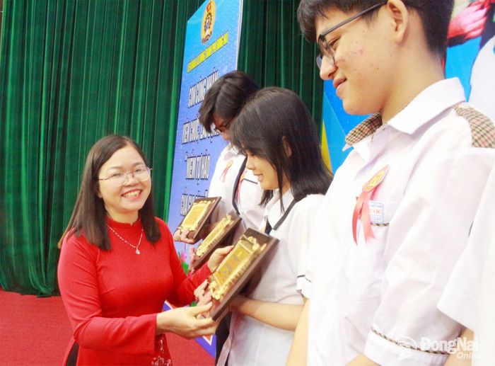 Phó Chủ tịch Liên đoàn Lao động thành phố Đồng Nai Nguyễn Thị Tuyết trao khen thưởng cho các em học sinh. Ảnh: N.Hòa