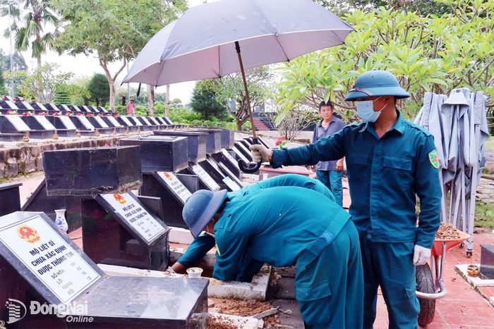 Lực lượng vũ trang xã Đồng Tâm thực hiện nhiệm vụ lấy mẫu xét nghiệm ADN tại Nghĩa trang liệt sĩ Bình Phước, xã Đồng Tâm, thành phố Đồng Nai. Ảnh: Nguyệt Hà