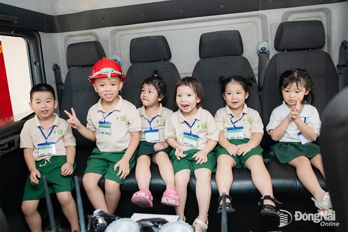 Các em học sinh tham quan, chụp hình lưu niệm cùng xe chữa cháy