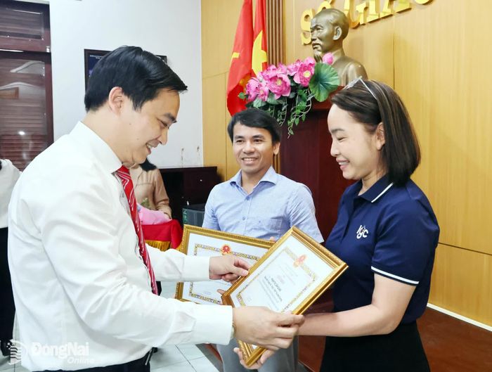 Tiến sĩ Đặng Anh Tuấn, Giám đốc Sở Giáo dục và Đào tạo trao giấy khen cho 2 giáo viên đã đồng hành cùng học sinh tại các cuộc thi quốc tế. Ảnh: Công Nghĩa